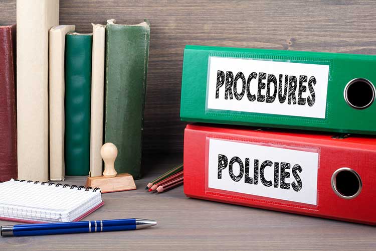 policies and procedures folders on a desk